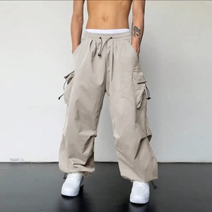 Détail du pantalon cargo beige clair avec taille à cordon et grandes poches latérales