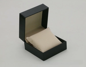 Detail of black flip-top watch box with lychee texture and beige velvet display pillow