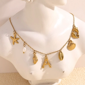 Detail of 18K gold plated necklace with starfish, pearl, and seashell ocean pendants