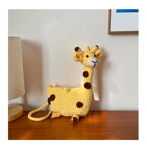 Detail of a handmade knitted giraffe crossbody bag with crochet yellow and brown textures