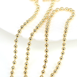 Polished gold beaded necklace with adjustable geometric round balls on a white background