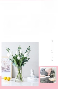 Close-up of white tulips and eucalyptus leaves in a clear glass vase for home decor