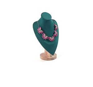 Macro detail of dark green velvet necklace bust display with a solid round wooden base