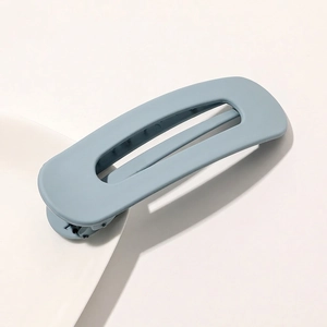 Macro shot of grey-blue matte duckbill hair clip with cutout design for minimalist styling