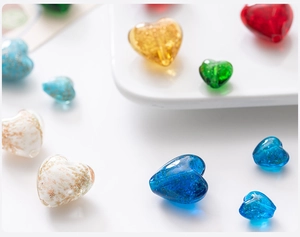 Close-up of colorful heart-shaped glass beads with glitter finish for jewelry making