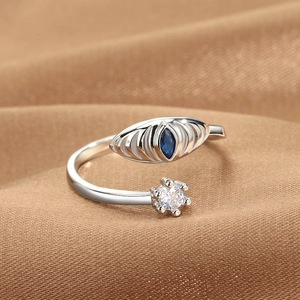 Silver open ring with blue marquise gem and white diamond on brown silk background