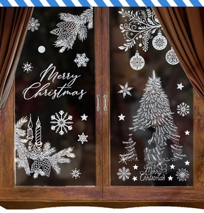 Detailed view of white Christmas tree and snowflake static window stickers on glass
