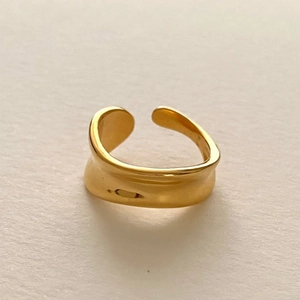 Detailed view of irregular wavy gold ring featuring polished finish and open design