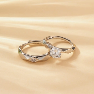 Detailed view of silver couple rings with geometric facets and sparkling zircon stones