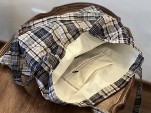 Internal view of quilted blue checkered tote bag with white lining and zipper pocket