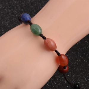 Colorful oval stone beaded woven bracelet with adjustable cord on display arm
