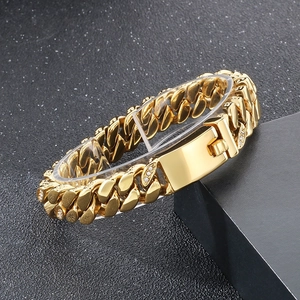 Macro shot of 12mm gold-plated Cuban link bracelet with diamonds on black background