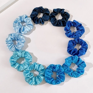 Set of 10 gradient blue satin hair scrunchies arranged in a circle for hair styling