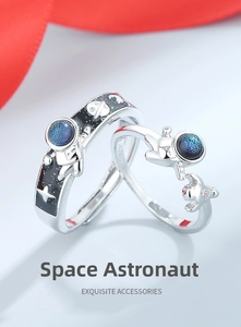 Macro detail of astronaut rings with blue glass stones and black enamel space motifs