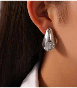 Gros plan de boucles d'oreilles gouttes argentées avec zircons sur un modèle