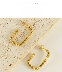 Detail view of 18K gold plated stainless steel twisted square hoop earrings on stone