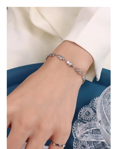 Detail shot of silver fish-shaped link bracelet with intricate engraved scale textures