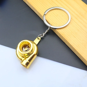 Detailed close-up of a golden metal turbocharger keychain with a polished finish and ring