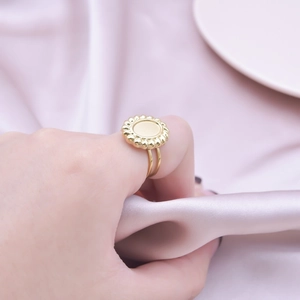 Macro shot of gold double-band ring with vintage floral tray on purple silk