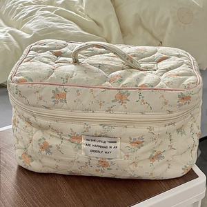 Detail of quilted cotton floral cosmetic bag with sturdy handle and dual zippers