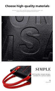 Detailed macro view of black lychee grain leather with embossed letters and red handles