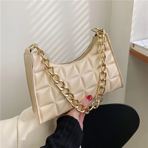 Detail of off-white quilted shoulder bag featuring premium texture and gold chain link
