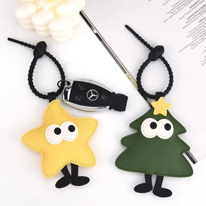 Christmas tree and star PU leather keychain with black silicone loop on white desk