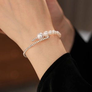 Detail view of pearl and diamond open bangle with gradient pearls and crystal pave on silver