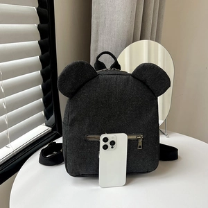 Black denim canvas mini backpack with cute mouse ears on top displayed on a white table