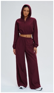Detail of burgundy windproof hooded jacket and high-waisted wide-leg sports pants set