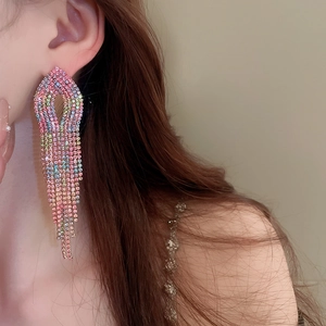Close-up of long tassel earrings with colorful gradient rhinestones on female model