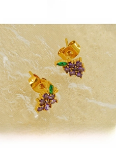 Macro view of gold-plated grape stud earrings with purple crystals and green leaf gems