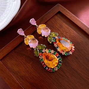 Macro shot of vintage style earrings with colorful zircon and amber waterdrop stones