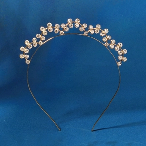 Elegant gold crown headband with sparkling rhinestones on a blue velvet background