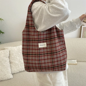 Detail of vintage plaid wool tote bag with brand label and spacious shoulder design