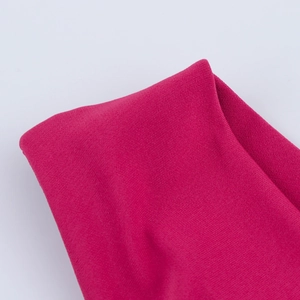 Vista macro dettagliata della trama del tessuto a maglia rosso rosa per abito in raso