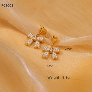 Detail showing gold heart bow earrings with white pearls and size measurements