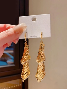 Close-up of gold mesh tassel earrings with S925 silver post in high-quality metallic finish