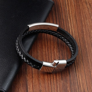 Detail of black braided leather men's bracelet with a polished stainless steel clasp
