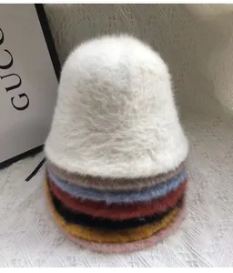 Detailed close-up showing stacked plush faux rabbit fur bucket hats in various colors