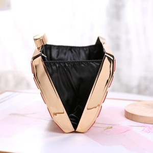 Detail view of the red acrylic evening bag featuring black satin lining and gold frame