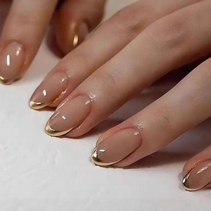 Classic French oval press-on nails with nude base and metallic gold mirror tips