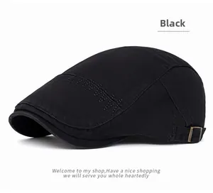 Detail of black cotton newsboy cap with decorative stitching and copper buckle adjustment
