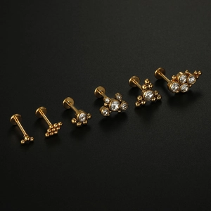 Set of six gold-plated labret studs with zircon crystals on a black background