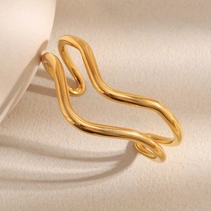 Detailed macro view of 18K gold plated stainless steel bracelet with twisted wave texture
