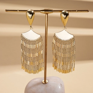 Detailed macro view of golden bohemian fan-shaped fringe earrings on a display
