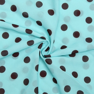 Detail of light blue chiffon fabric with dark brown polka dots in soft elegant swirls