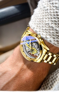 Close-up of golden automatic mechanical watch featuring a skeleton dial and gear movement