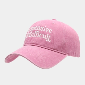 Close-up of pink washed cotton baseball cap with white Expensive & Difficult embroidery