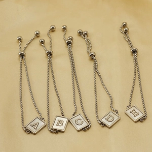 Detailed view of silver stainless steel adjustable bracelets with letter A-E shell charms